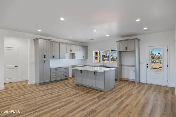 a kitchen with kitchen island white cabinets and stainless steel appliances