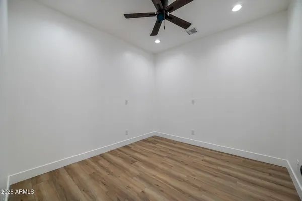 an empty room with a ceiling fan and carpet