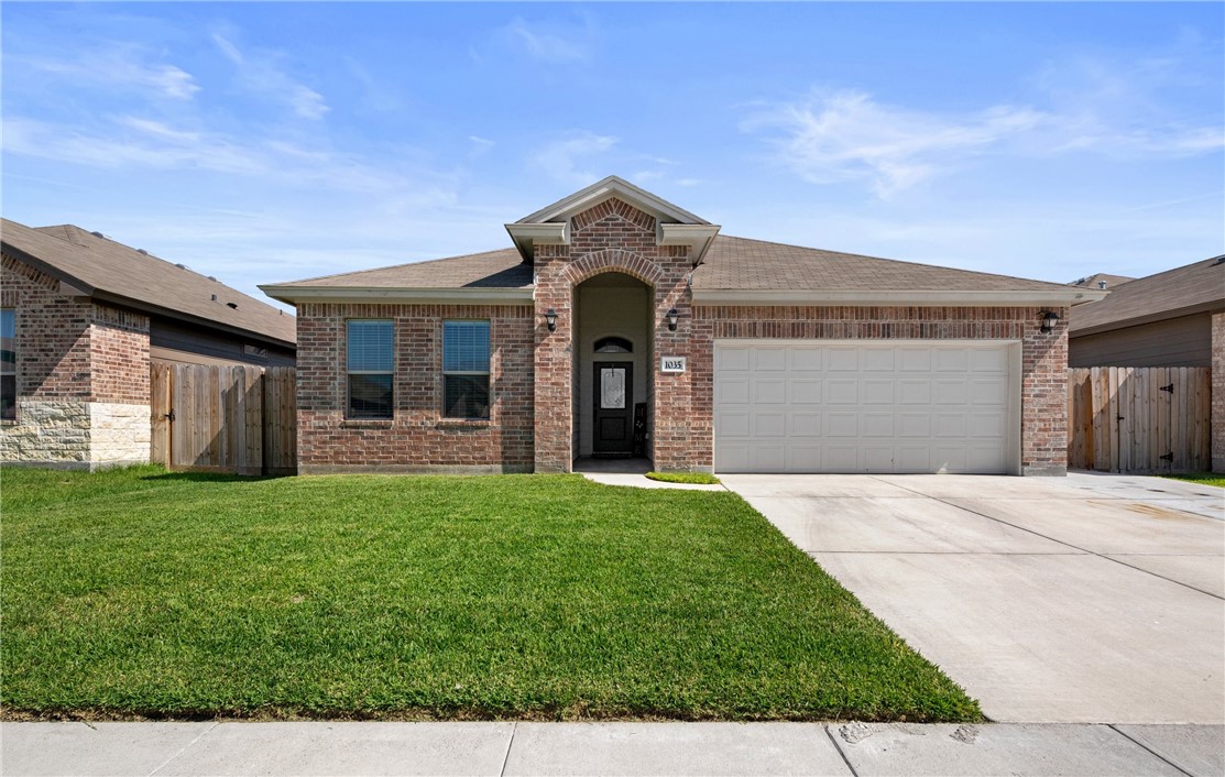 a front view of a house with a yard and garage