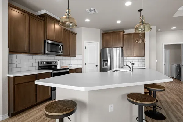 a large kitchen with a dining table chairs wooden floor and a kitchen view