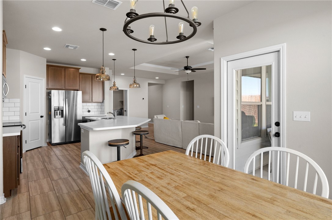 1035 Ocean Breeze Portland, TX 78374 - Photo 15 of 24 a large kitchen with a dining table chairs wooden floor and a kitchen view