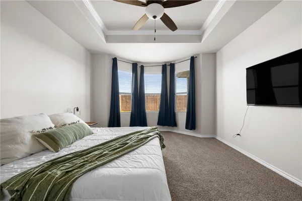 a spacious bedroom with a bed and a flat screen tv