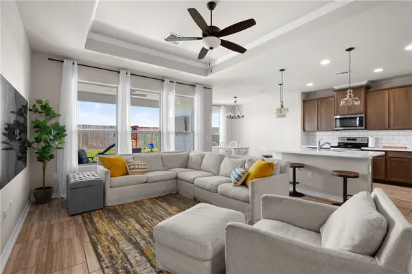 a living room with stainless steel appliances kitchen island a couches and kitchen view