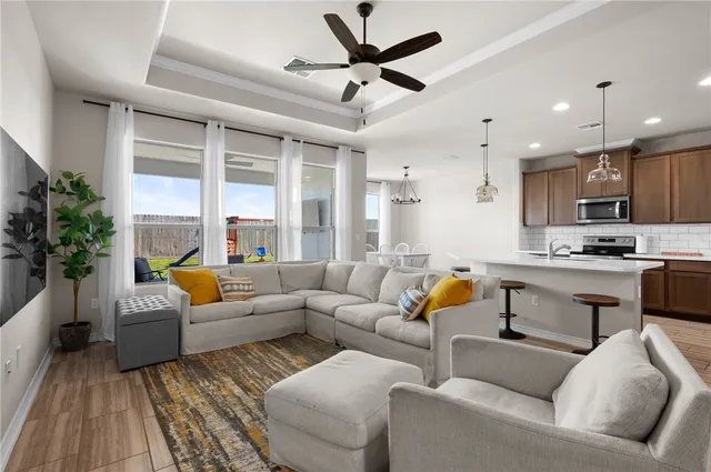 a living room with stainless steel appliances kitchen island a couches and kitchen view