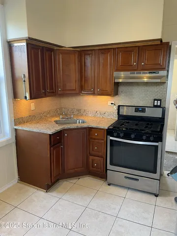 a kitchen with granite countertop a stove and a cabinets