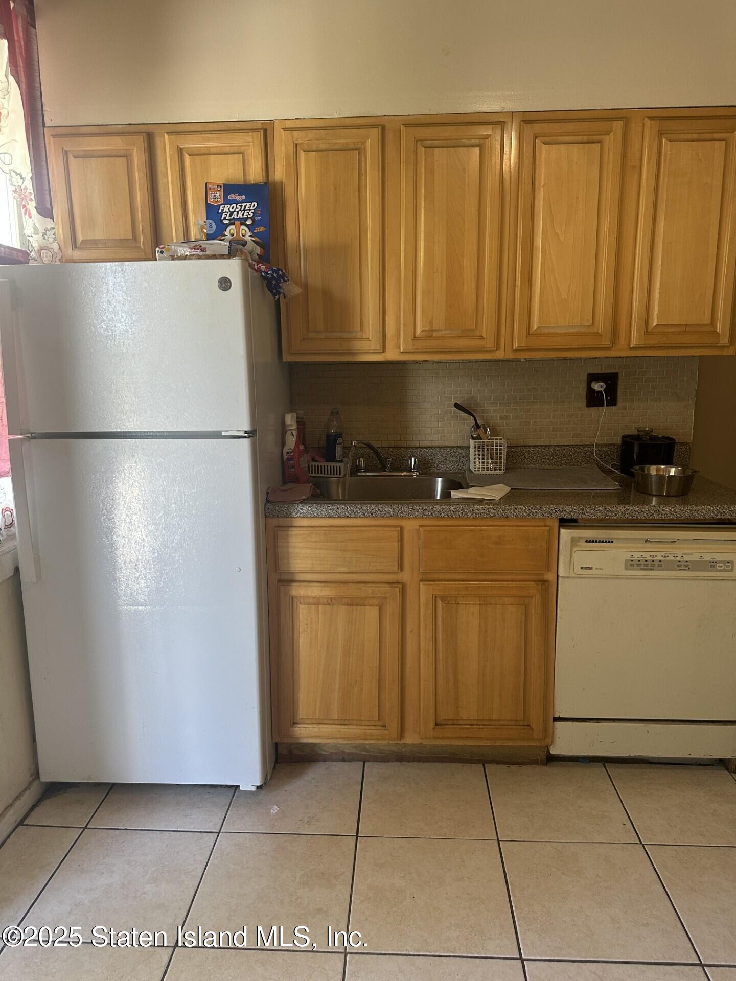 69 Narrows Road North Staten Island, NY 10305 - Photo 5 of 15 a kitchen with a refrigerator a stove a washer and dryer