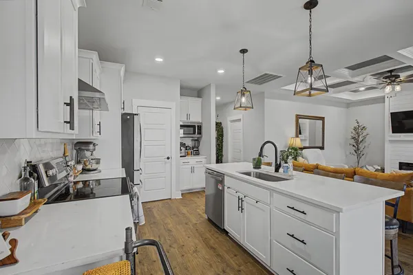 a large kitchen with sink refrigerator and cabinets