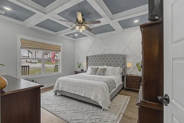a bedroom with a large bed and a chandelier