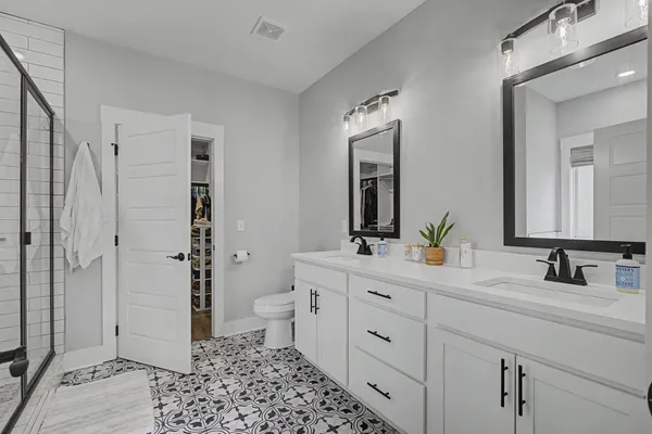 a bathroom with a double vanity sink mirror and toilet