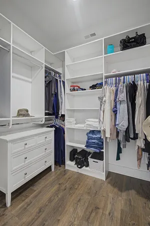 a view of walk in closet with clothes and shoes