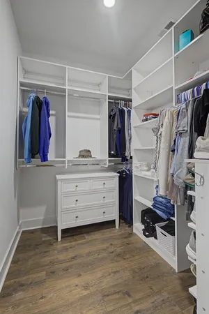 a view of walk in closet with clothes and shoes