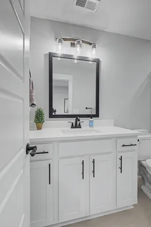 a bathroom with a sink vanity and a mirror