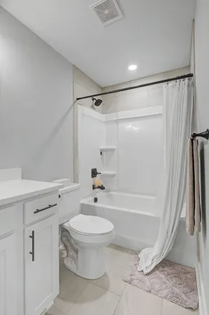 a bathroom with a shower a toilet and a tub