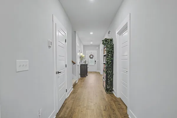 a view of a hallway with wooden floor and staircase