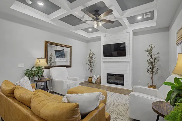 a living room with furniture a fireplace and a flat screen tv
