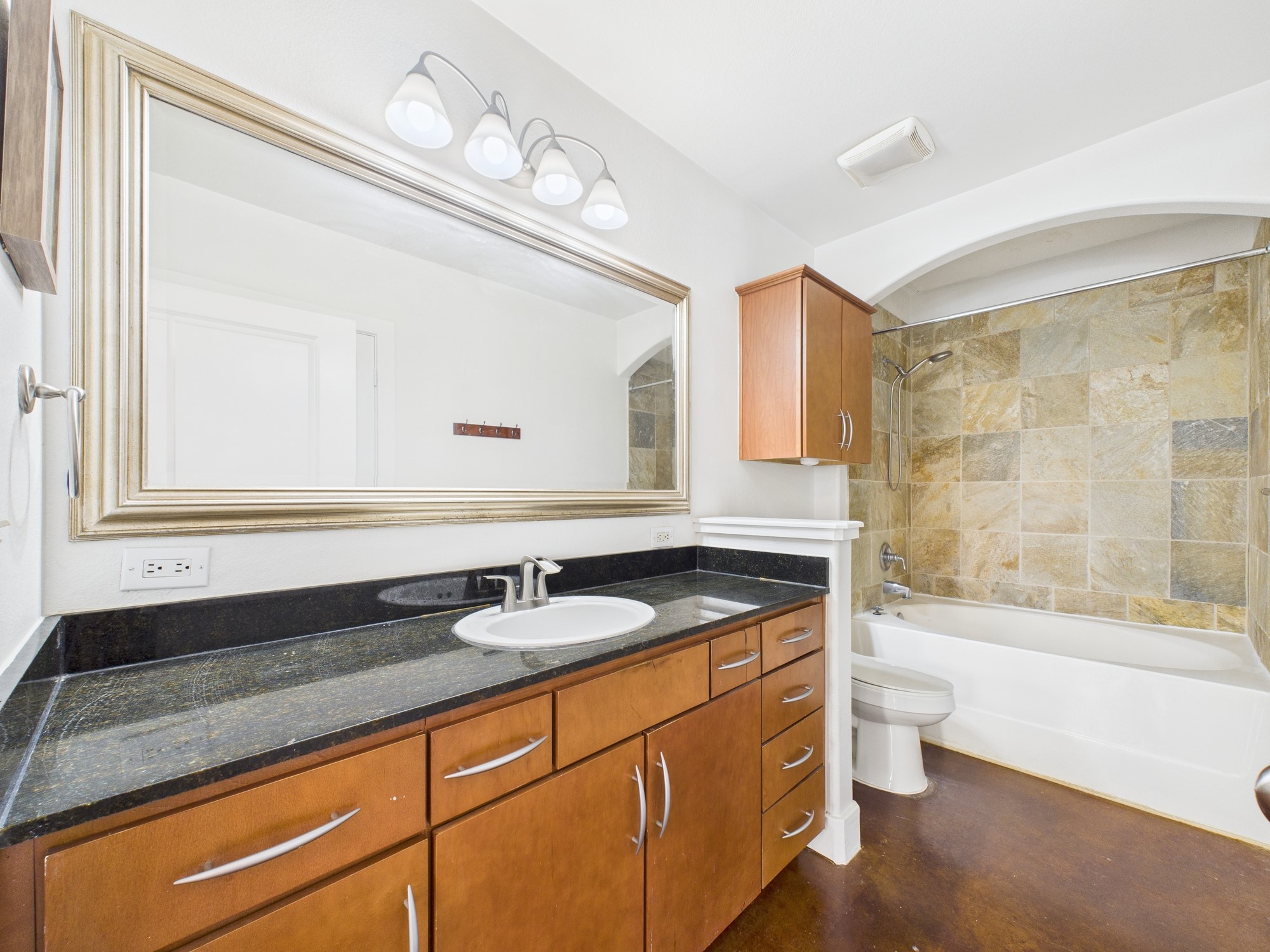 1901 Post Oak Boulevard, Unit 1405 Houston, TX 77056 - Photo 22 of 25 a bathroom with a granite countertop sink a toilet a mirror and bathtub