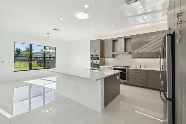 a large kitchen with kitchen island a sink stainless steel appliances and cabinets