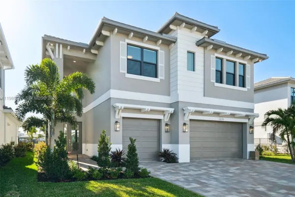 front view of a house with a yard and a garden