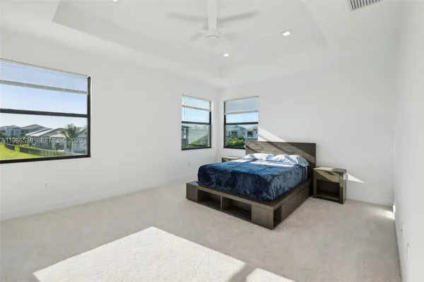 a bedroom with a bed mirror and window
