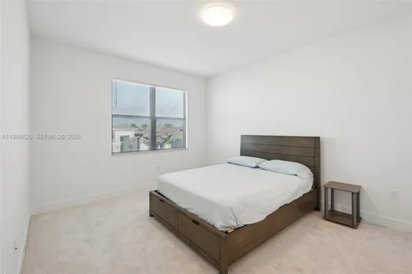 a bed sitting in a bedroom next to a window