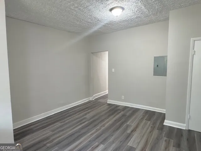 a view of an empty room with wooden floor