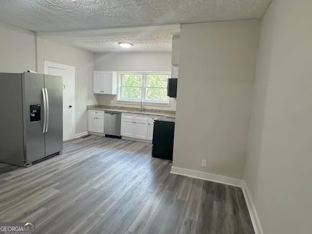 a kitchen with wooden floors and refrigerator