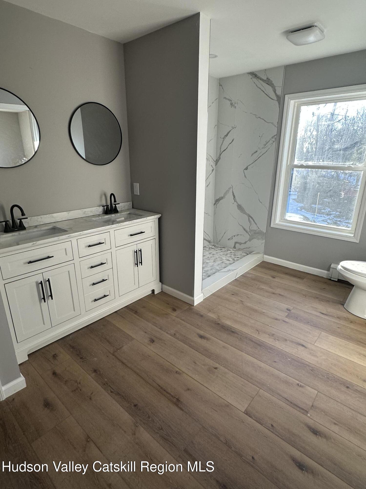 35 Olivers Way Cairo, NY 12413 - Photo 19 of 22 a spacious bathroom with a granite countertop sink and a mirror