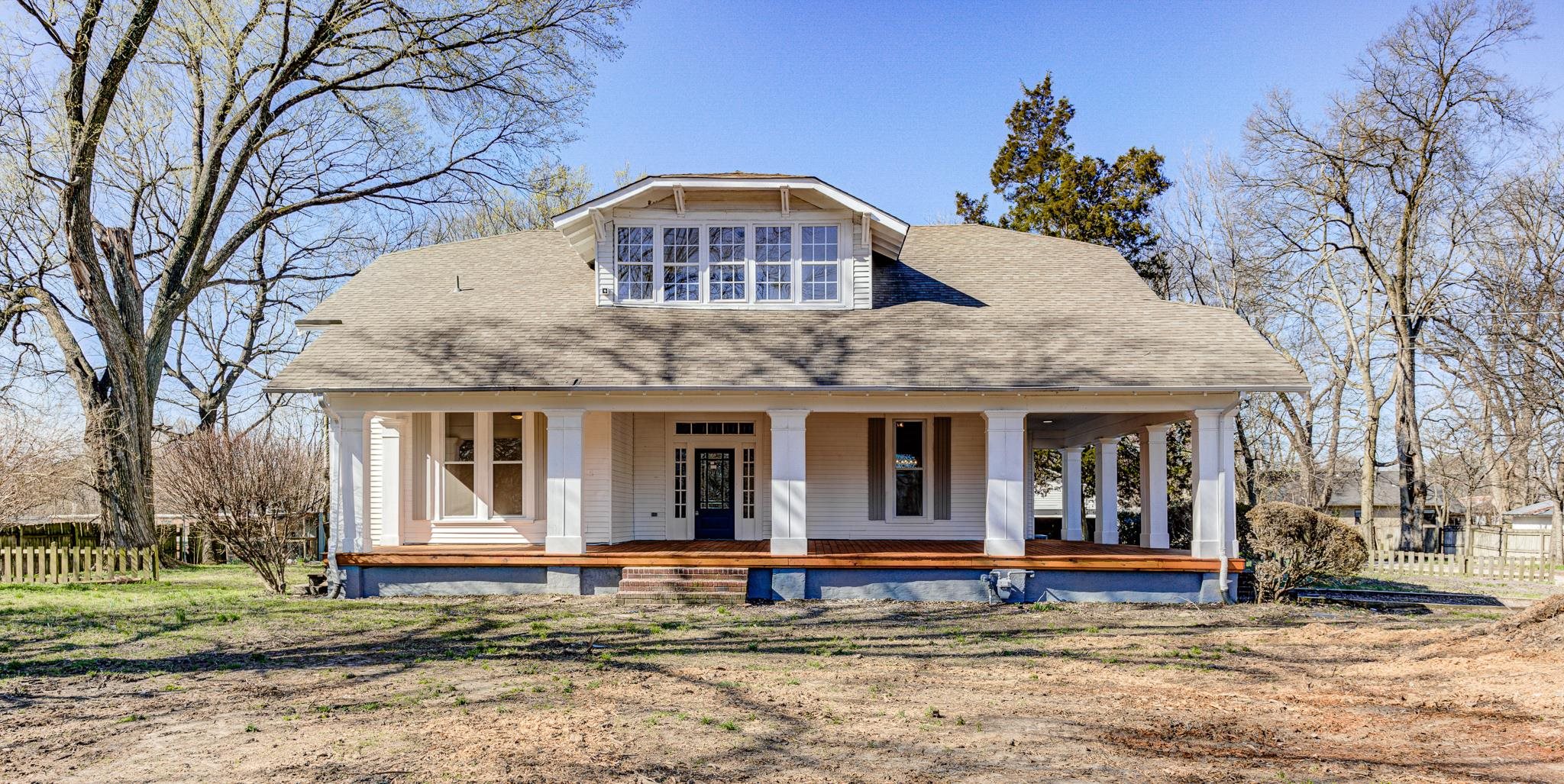 843 South Main Street Covington, TN 38019 - Photo 1 of 25 a view of a white house with large windows and a small yard