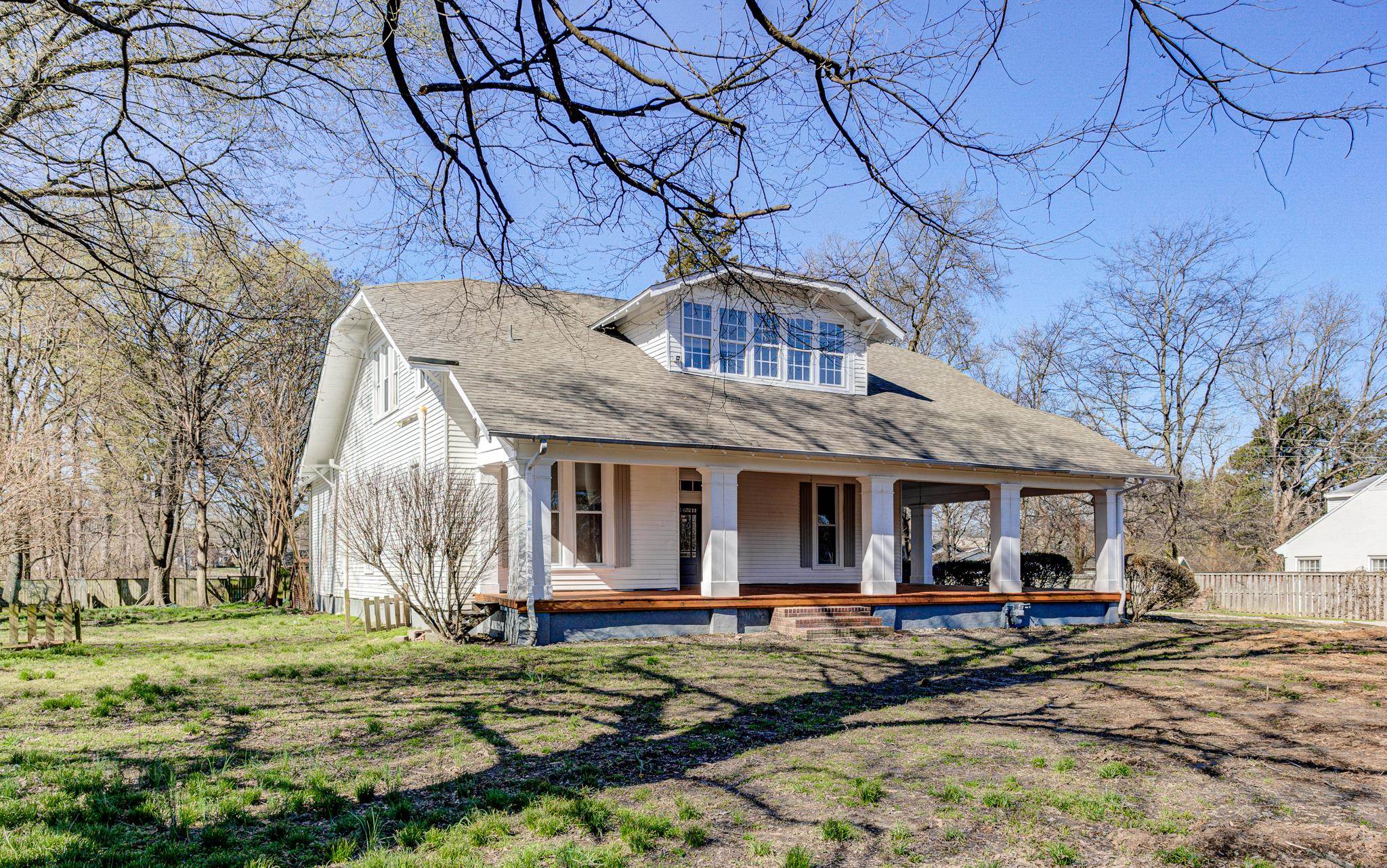 843 South Main Street Covington, TN 38019 - Photo 22 of 25 a view of a white house with a large tree and wooden fence