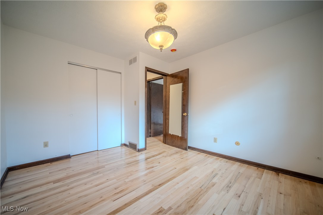 698 Albert Horning Road Atwater, OH 44201 - Photo 35 of 40 Unfurnished bedroom with light wood-style flooring and a closet