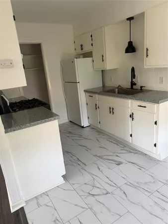 a kitchen with white cabinets and white appliances