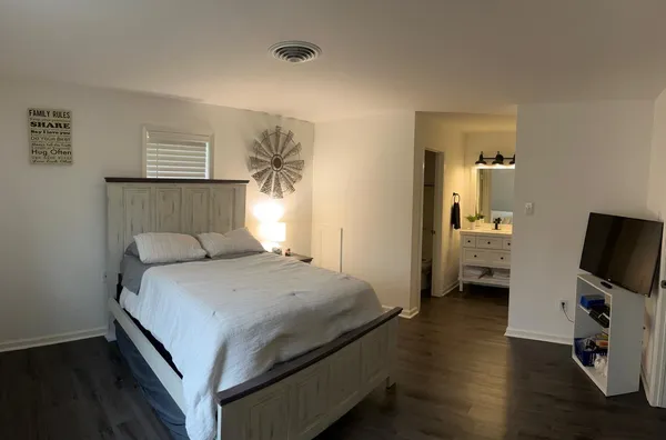 a bedroom with a bed and a flat screen tv