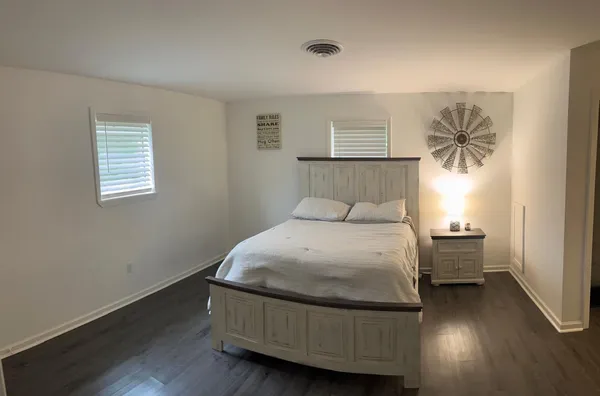 a bedroom with a bed and wooden floor