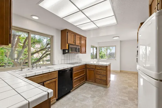 a kitchen with stainless steel appliances granite countertop a sink and a stove