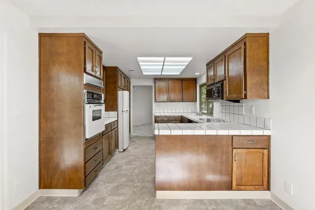 a kitchen with stainless steel appliances granite countertop a refrigerator and a stove top oven
