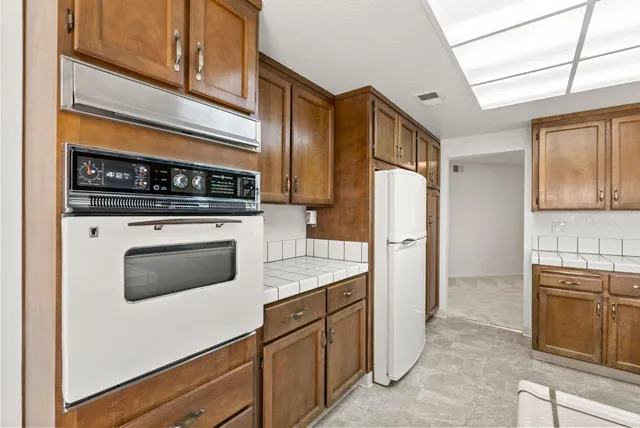 a kitchen with stainless steel appliances granite countertop a refrigerator stove and sink