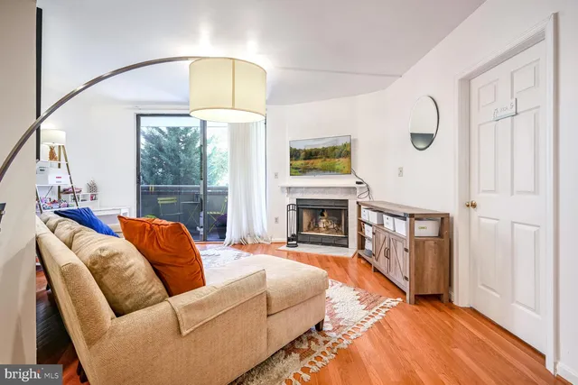 a living room with furniture a fireplace and a large window