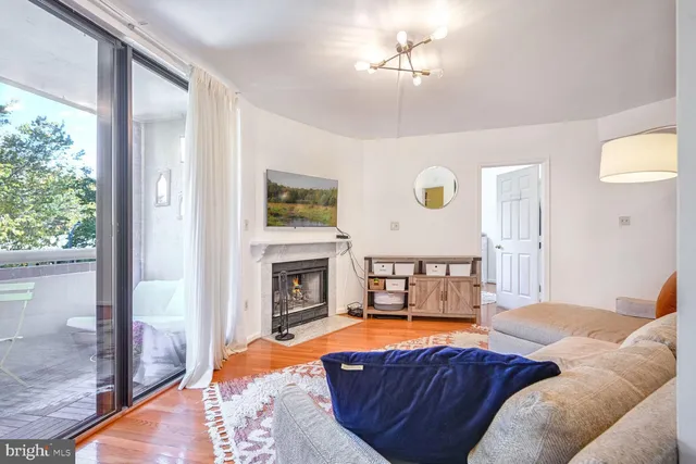 a living room with furniture a fireplace and a window
