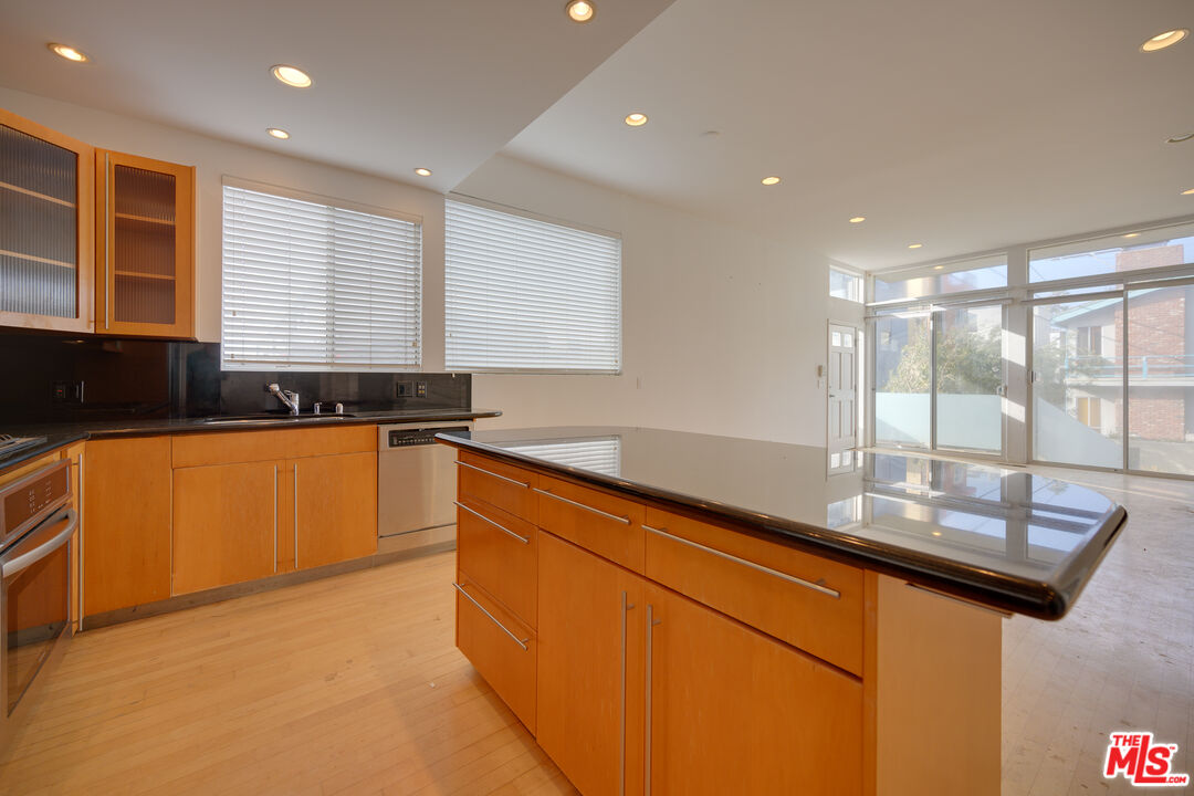 14 Privateer Street, Unit 1 Marina del Rey, CA 90292 - Photo 12 of 32 a kitchen with granite countertop sink and cabinets
