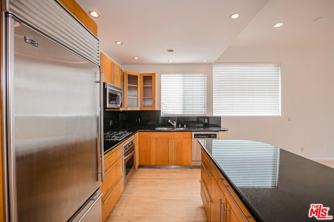 14 Privateer Street, Unit 1 Marina del Rey, CA 90292 - Photo 13 of 32 a kitchen with stainless steel appliances granite countertop a refrigerator a sink and a stove
