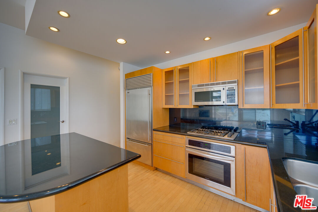 14 Privateer Street, Unit 1 Marina del Rey, CA 90292 - Photo 10 of 32 a kitchen with stainless steel appliances granite countertop a stove a sink and a microwave