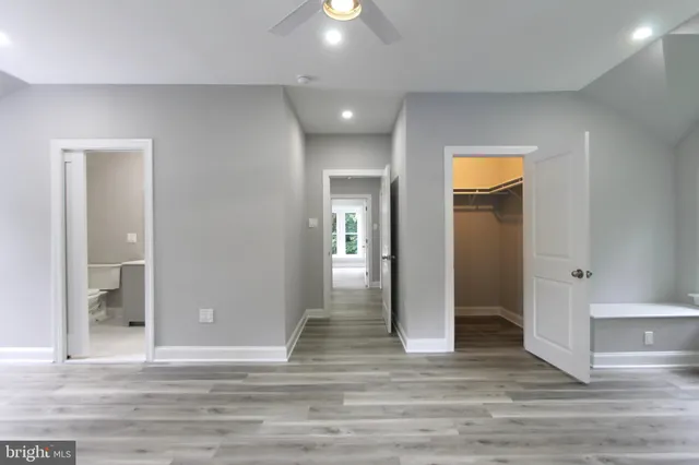 a view of a hallway with wooden floor and a living room