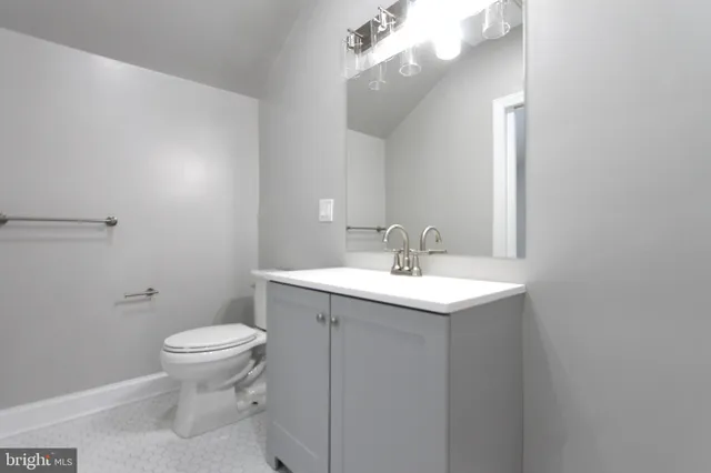 a bathroom with a toilet a sink and mirror