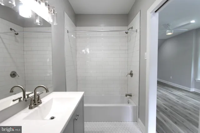 a bathroom with a bathtub shower sink vanity and a toilet
