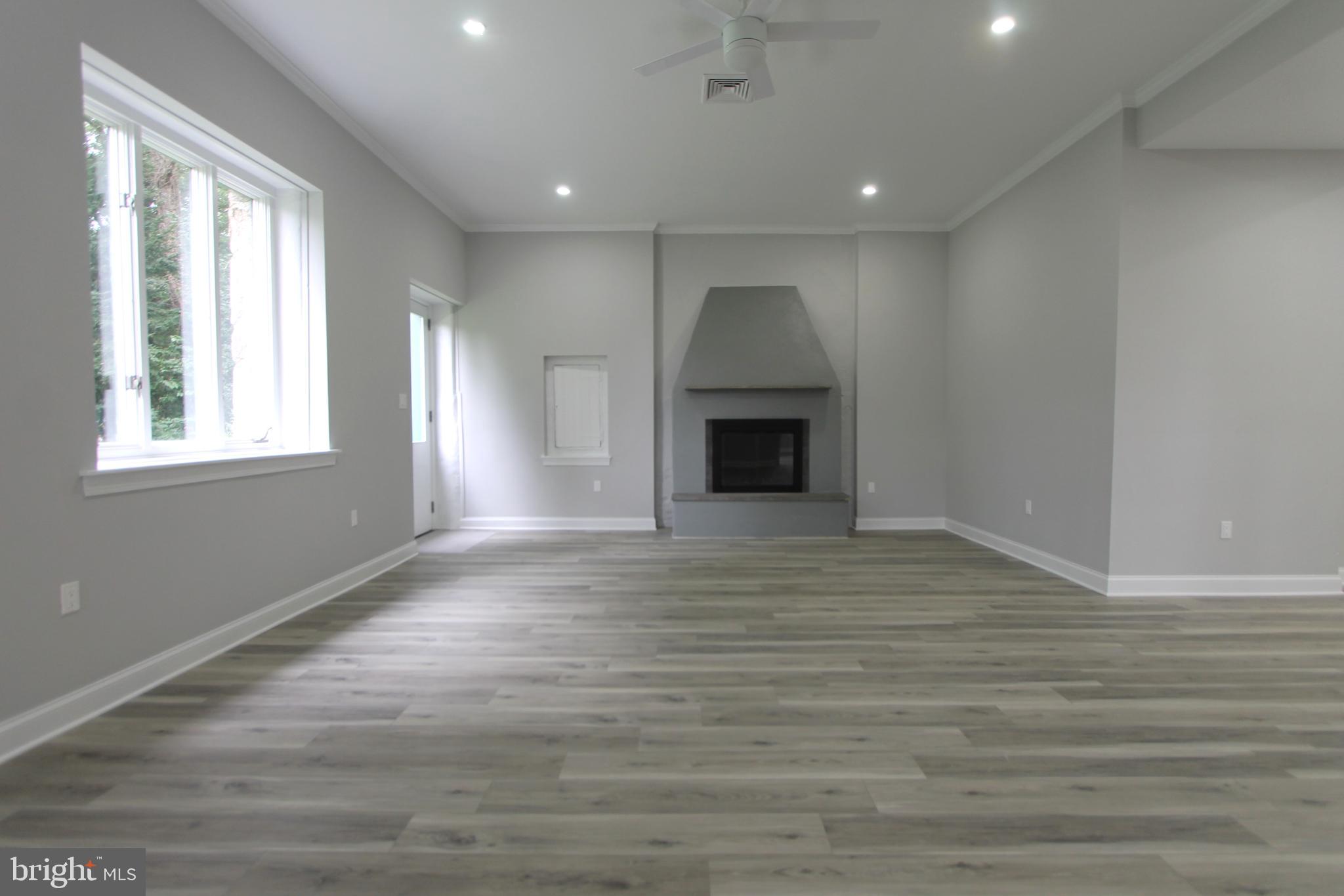 5925-31 Devon Place Philadelphia, PA 19138 - Photo 5 of 27 an empty room with wooden floor fireplace and windows