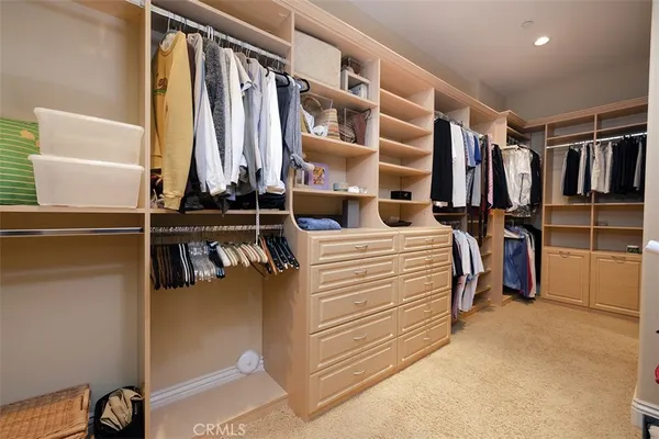 a view of walk in closet with clothes and shoes