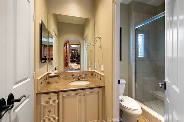a bathroom with a granite countertop sink toilet and shower