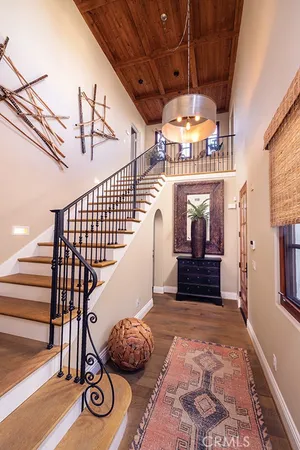 a view of a hallway with wooden floor a chandelier and entryway