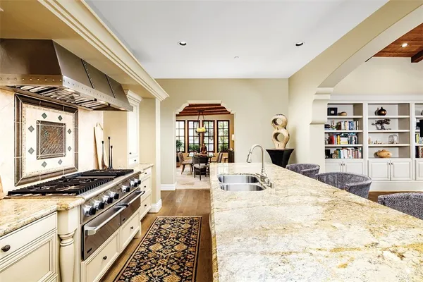 a kitchen with stainless steel appliances kitchen island granite countertop a stove and a cabinets