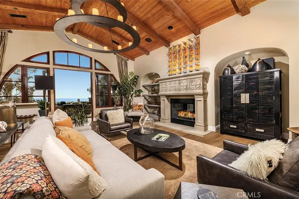 a living room with furniture a fireplace and a chandelier